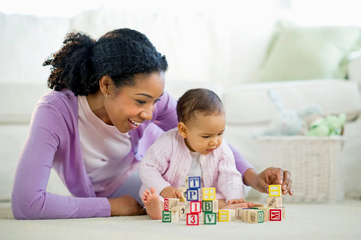 Woman playing with blocks with baby girl