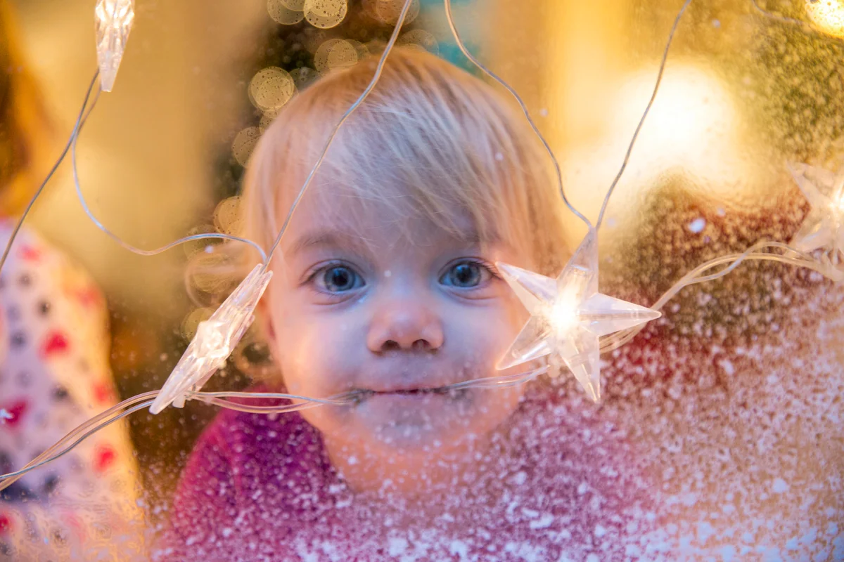 Baby girl looking out of window with Christmas star