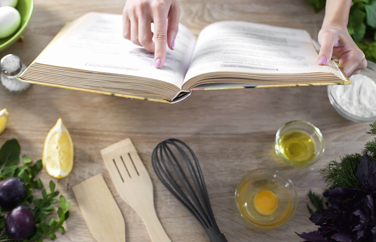 Lady reading pizza recipe in culinary book
