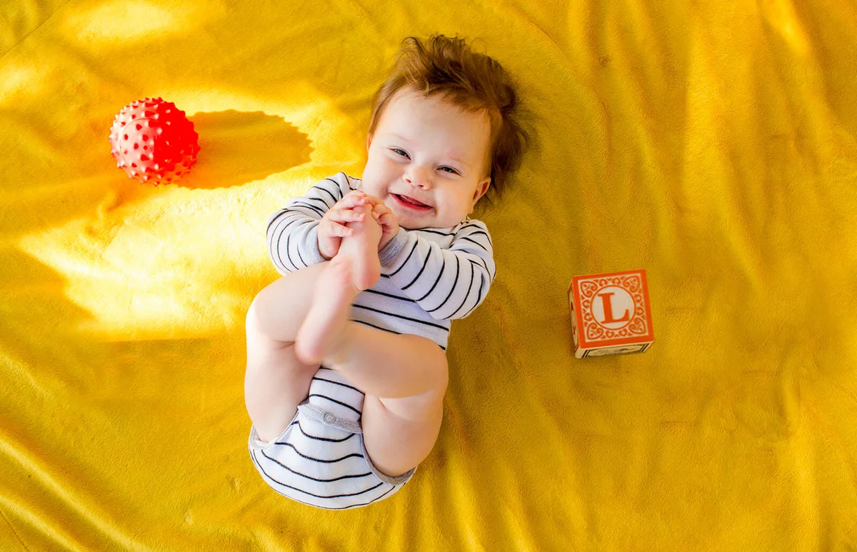 baby playing with blocks on bed