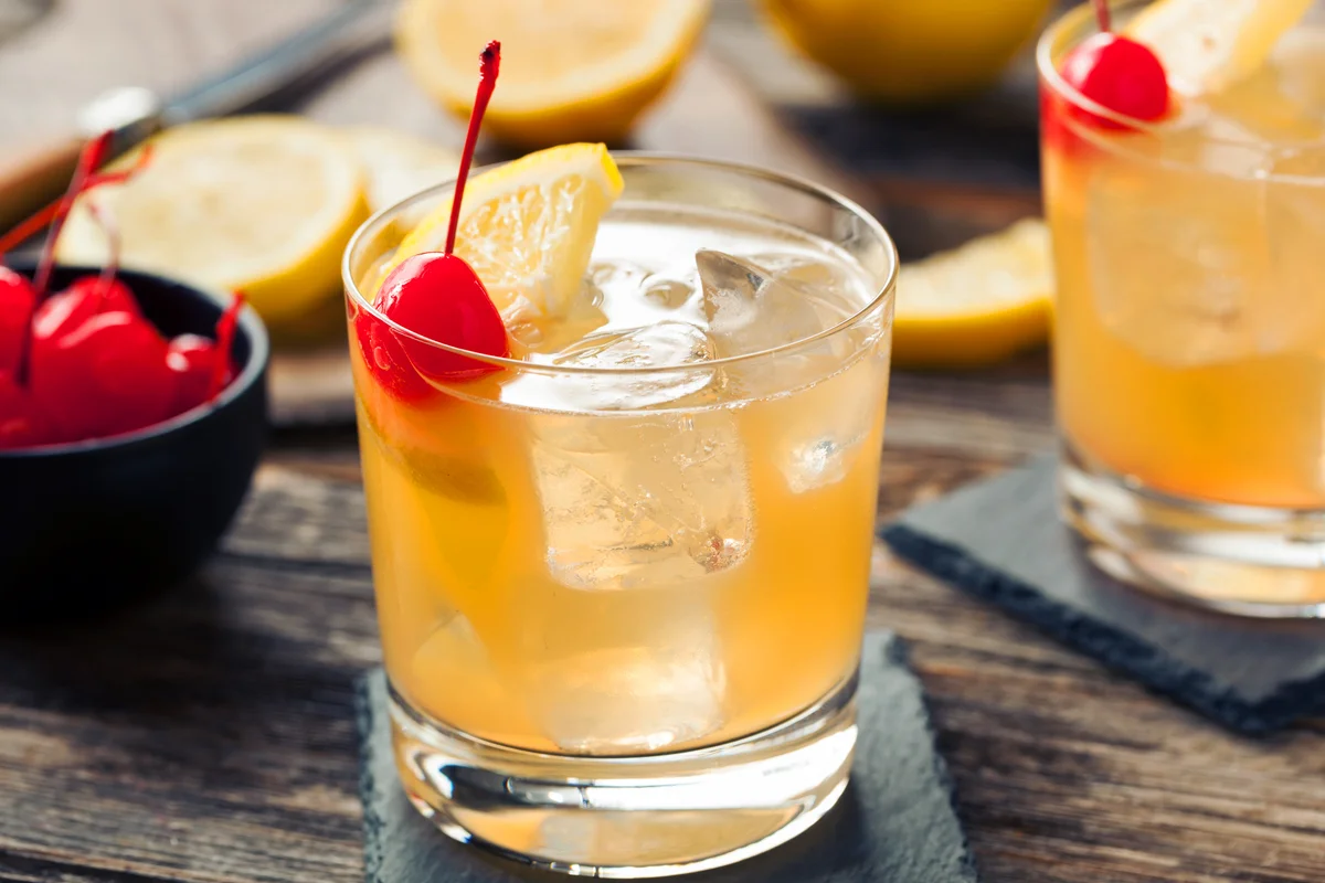 Whiskey Sour Cocktail Drink with a Cherry and Lemon