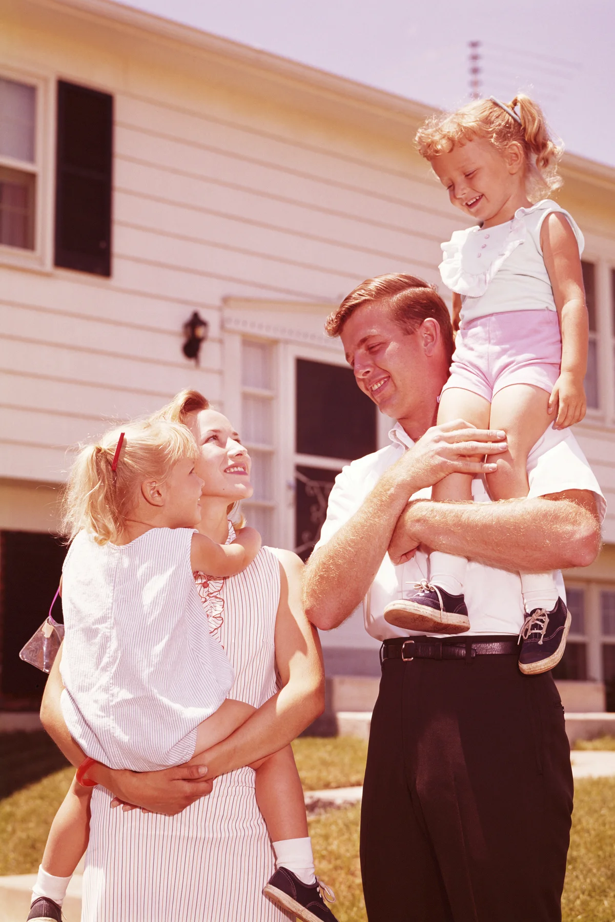 Family outside suburban home in the 1960s