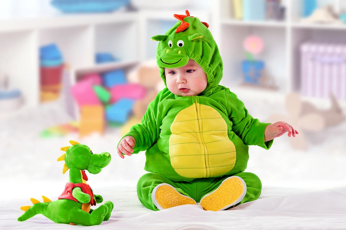 Baby boy in a green suit of a dragon