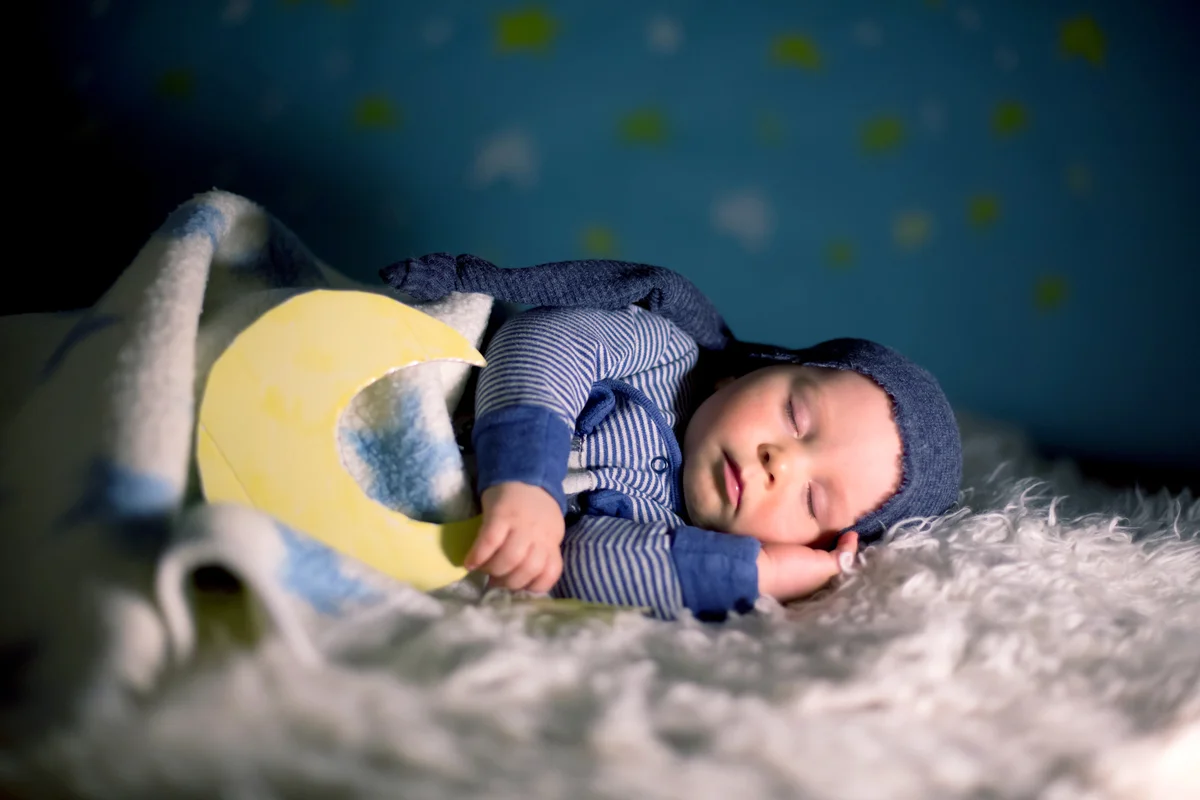 Little baby boy with cute teddy bear and moon