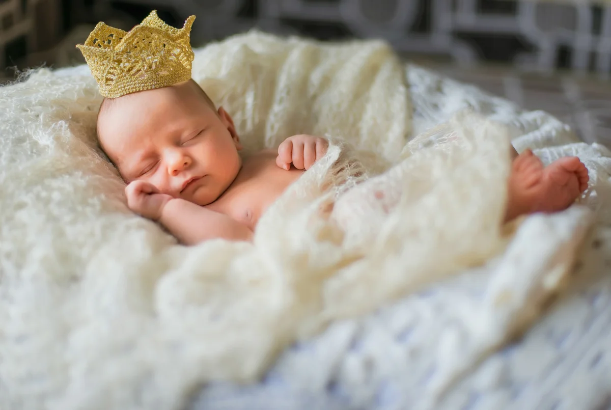 Sleeping newborn wearing a crown