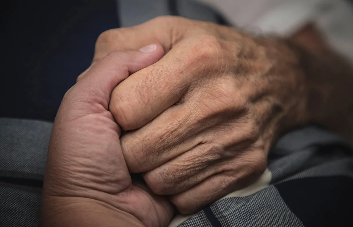Hospice nurse helping an elderly man
