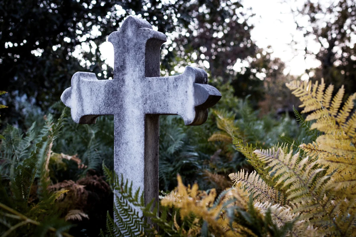 Granite cross in the middle of an abandoned cemetery