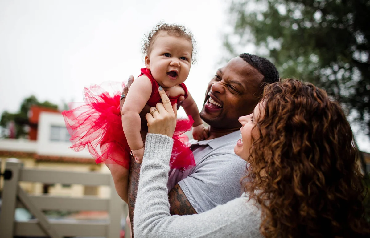 Couple Holding & Smiling at Baby