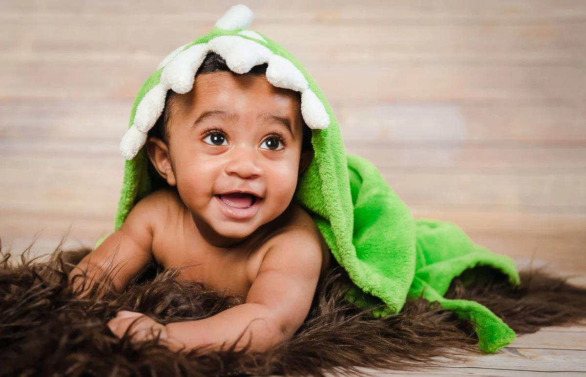 boy wearing bath robe laying on tummy belly