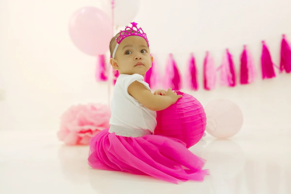Cute Baby Girl In Dress With Party Decoration