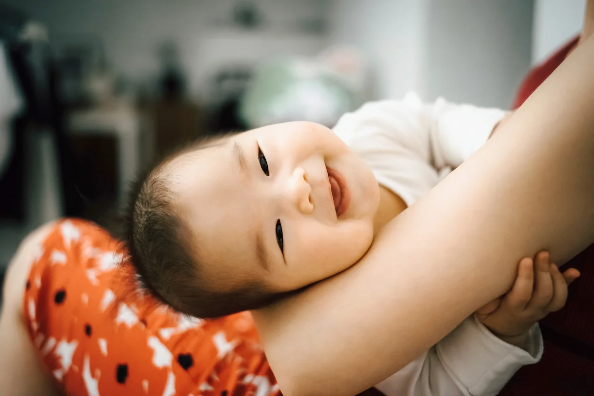 Mother embracing smiling cute baby in her arms