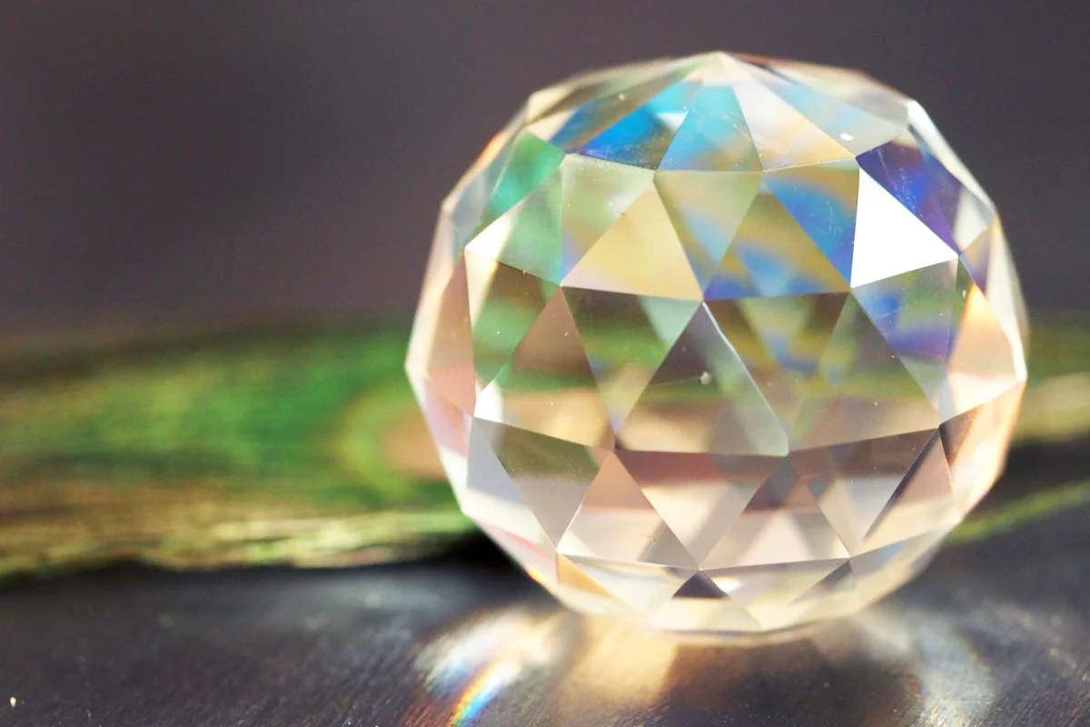 A Peacock Feather Reflecting in a Faceted Crystal