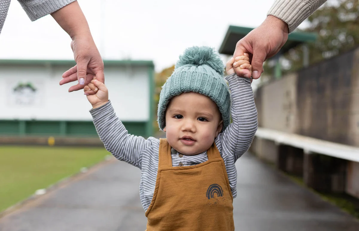 close up of toddler holding hand with parents