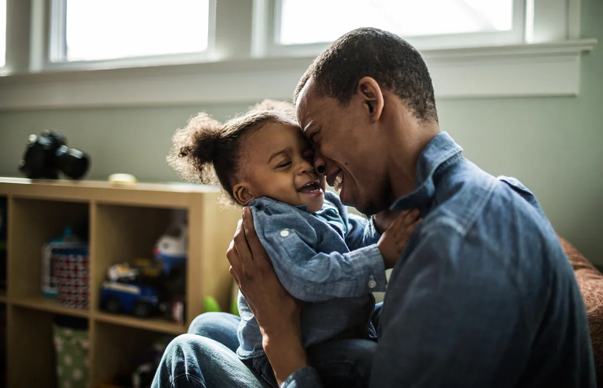 Father laughing with toddler daughter