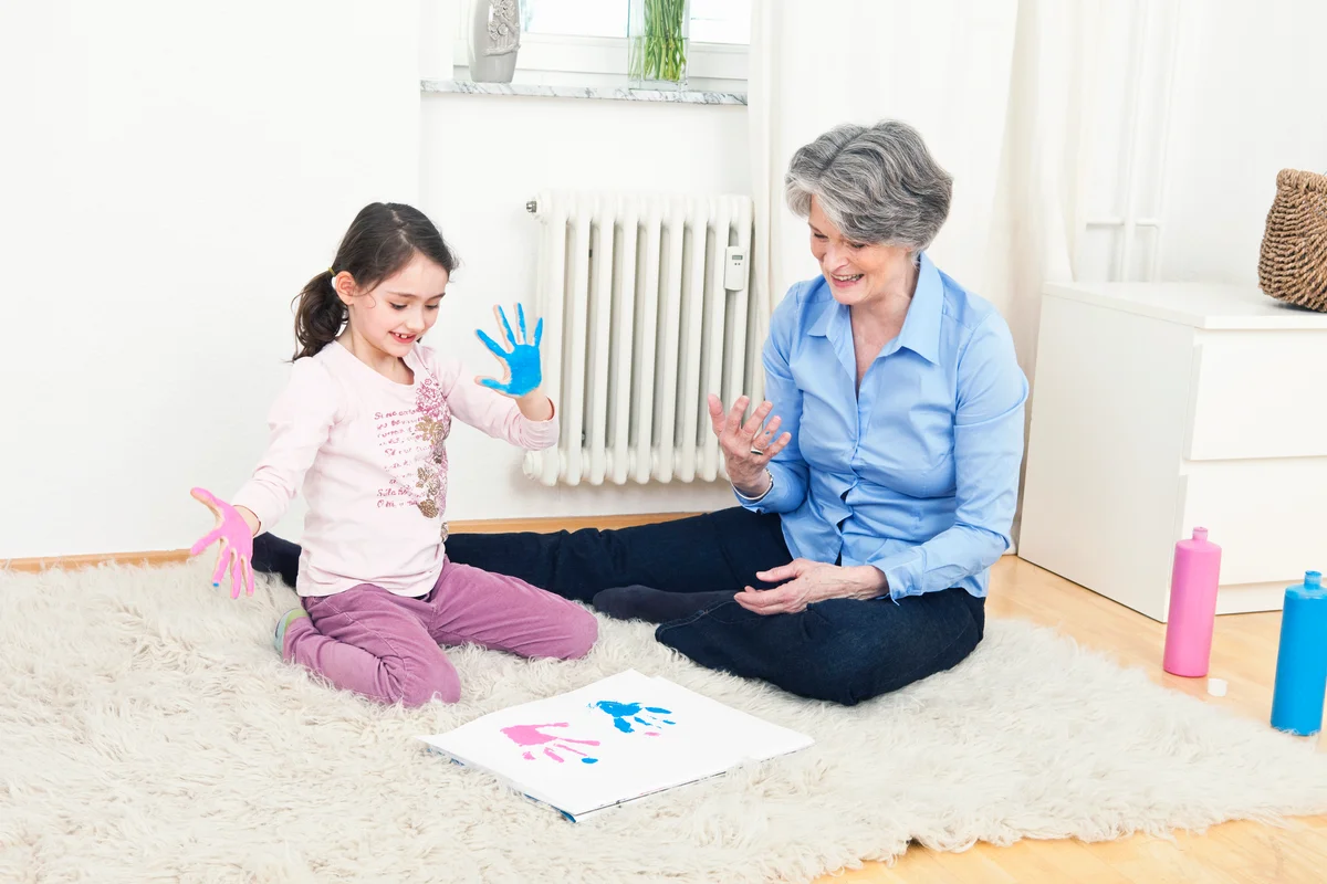 Grandmother and granddaughter finger painting