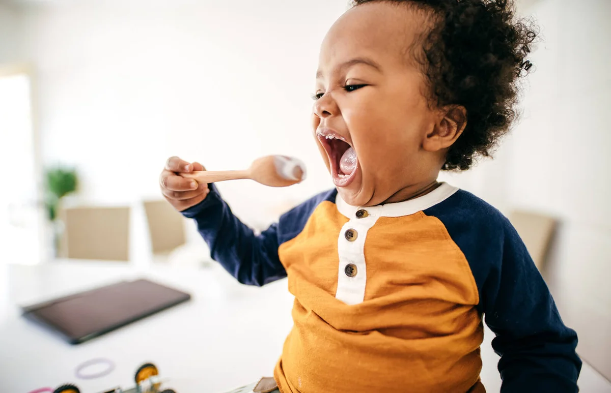 Toddler eating yogurt