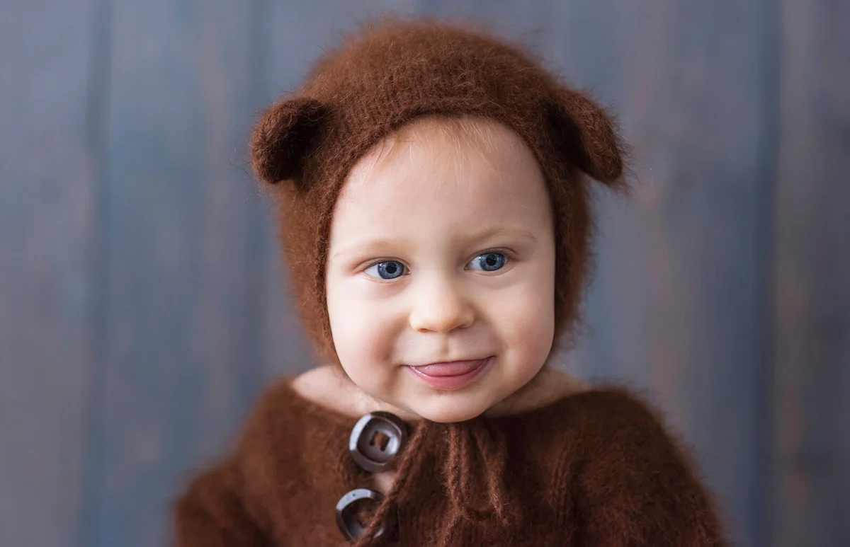 portrait of a little boy in a brown, fluffy, knitted bear costume