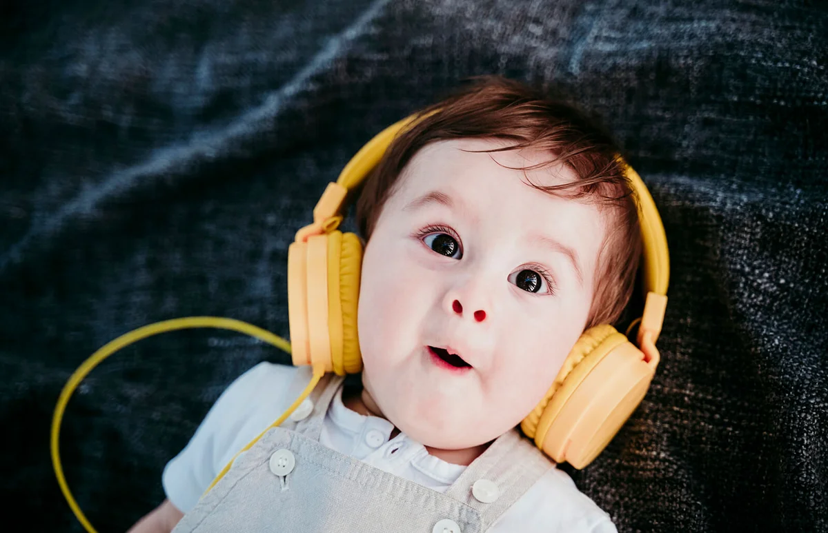Cute baby boy wearing headphones making facial expression