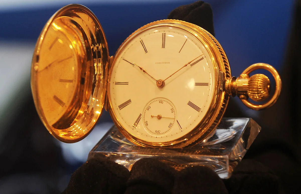 Detail of a vintage 1872 Longines pocket hunter timepiece, adorned in 14K gold with key winding mechanism, is pictured in Kolkata on August 27, 2013 | Getty Editorial Use