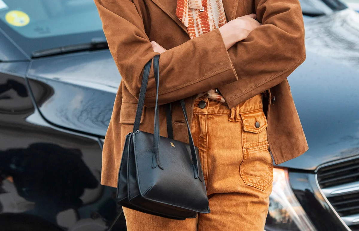 Model Justine Soranzo wears a Gerard Darel jacket, shirt, trousers, Rouje bag and Gucci sunglasses on February 27, 2020 in Paris, France | Getty Editorial Use