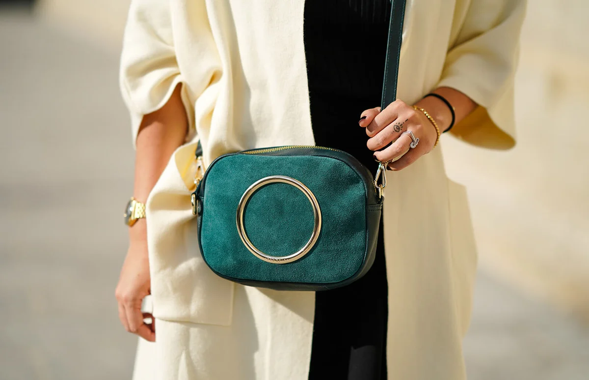 Nikita Wong wears a green Sequoia bag with a golden metallic circular insert, on October 18, 2020 in Paris, France | Getty Editorial Use