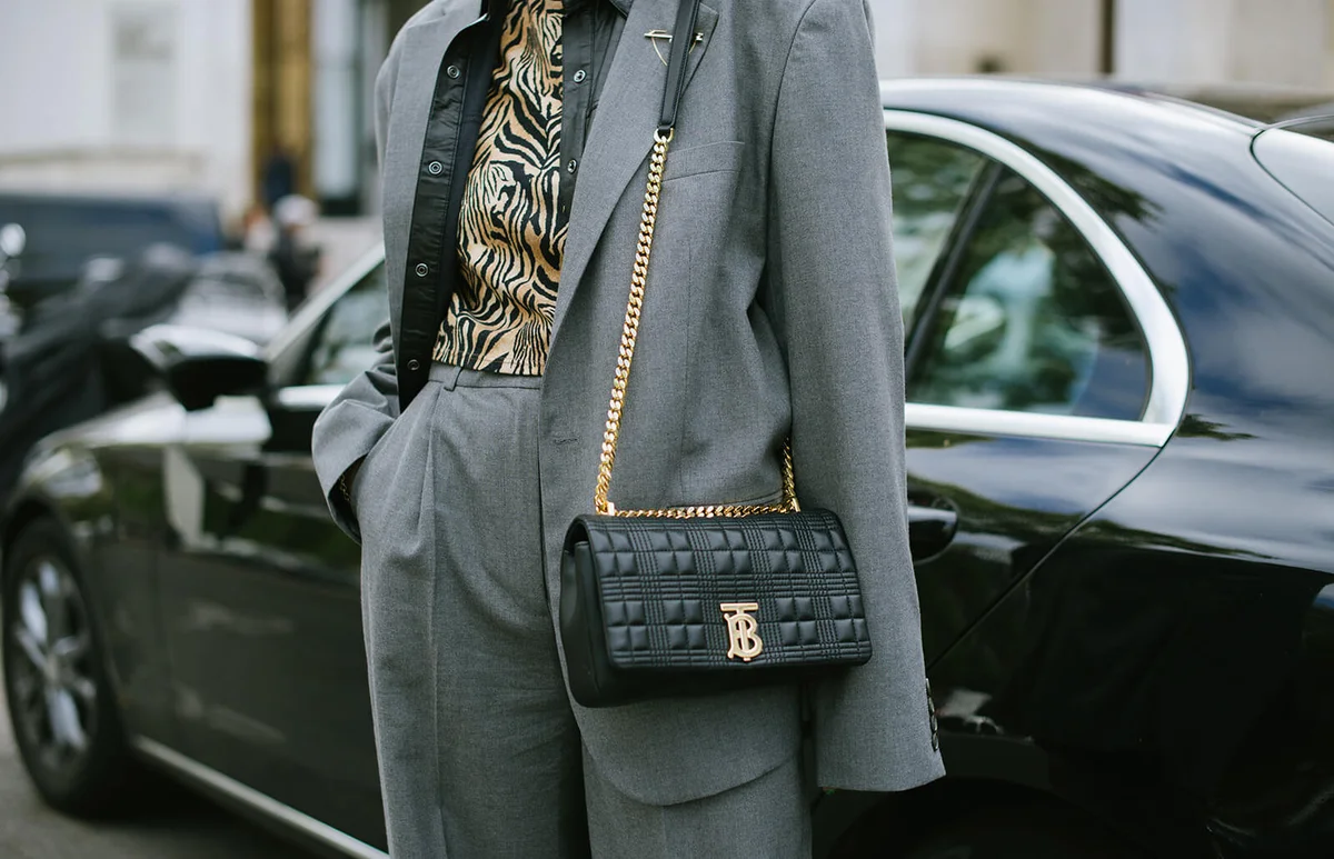 A guest poses with a Burberry bag after the Aider Hackermann show at the Palais de Tokyo during Paris Fashion Week | Getty Editorial Use