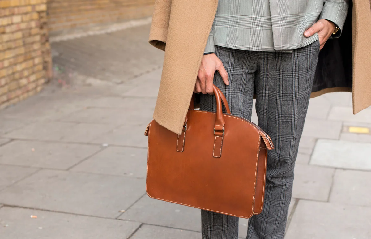 Fashion stylist Steven Doan wearing a Reiss coat, Giorgio Armani blazer, Hugo Boss trousers suit and Tusting bag on day 1 of London Collections | Getty Editorial Use