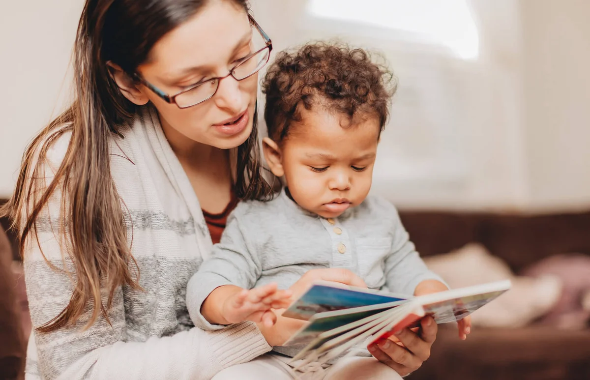 Mother And Son Reading Book At Home