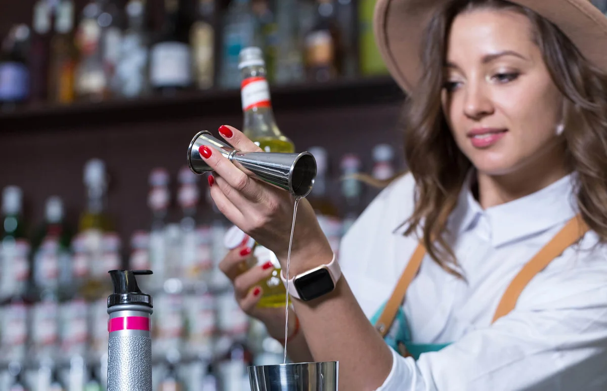The bartender adds syrup to the shaker