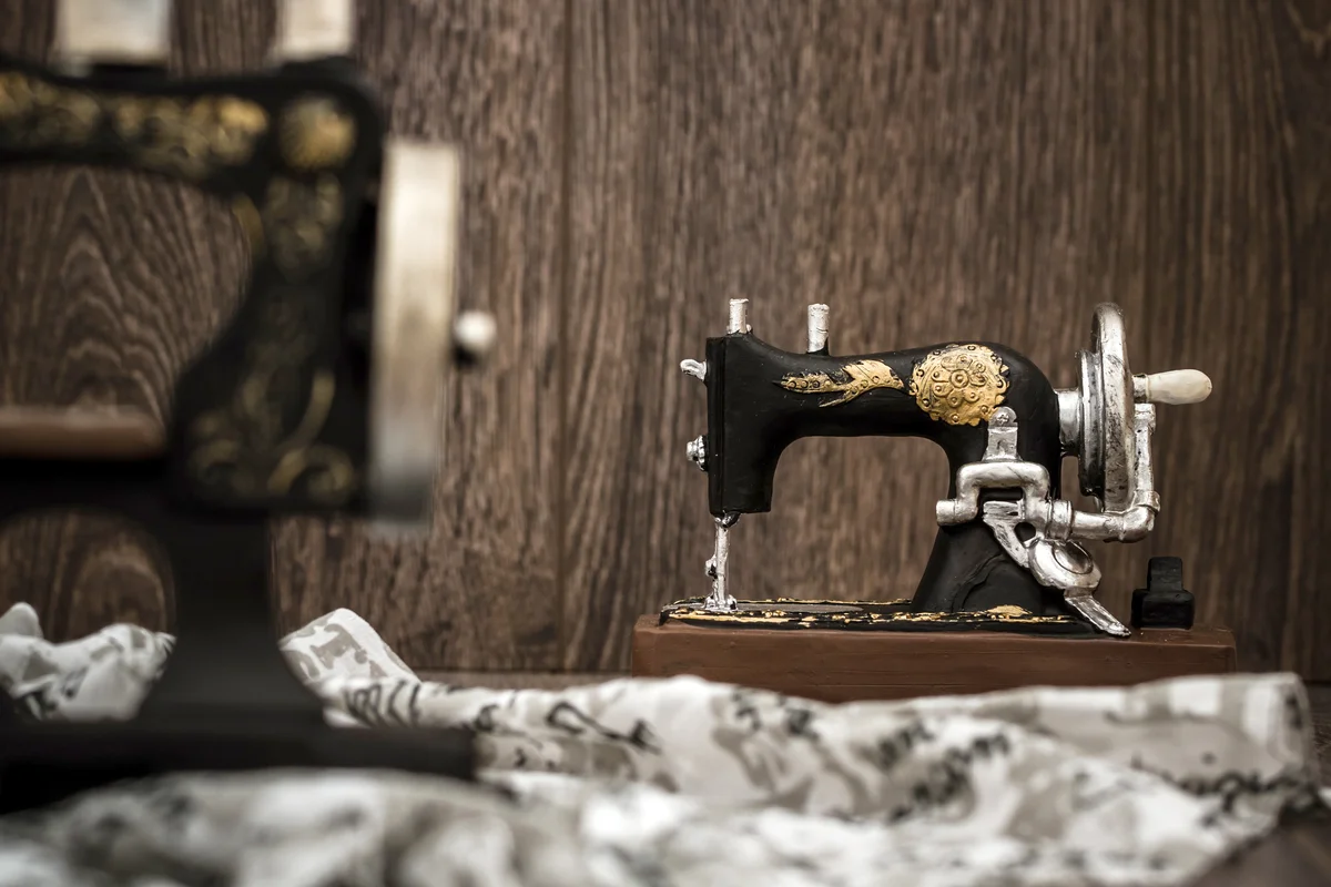 Small nostalgic decorative sewing machine on brown wooden background