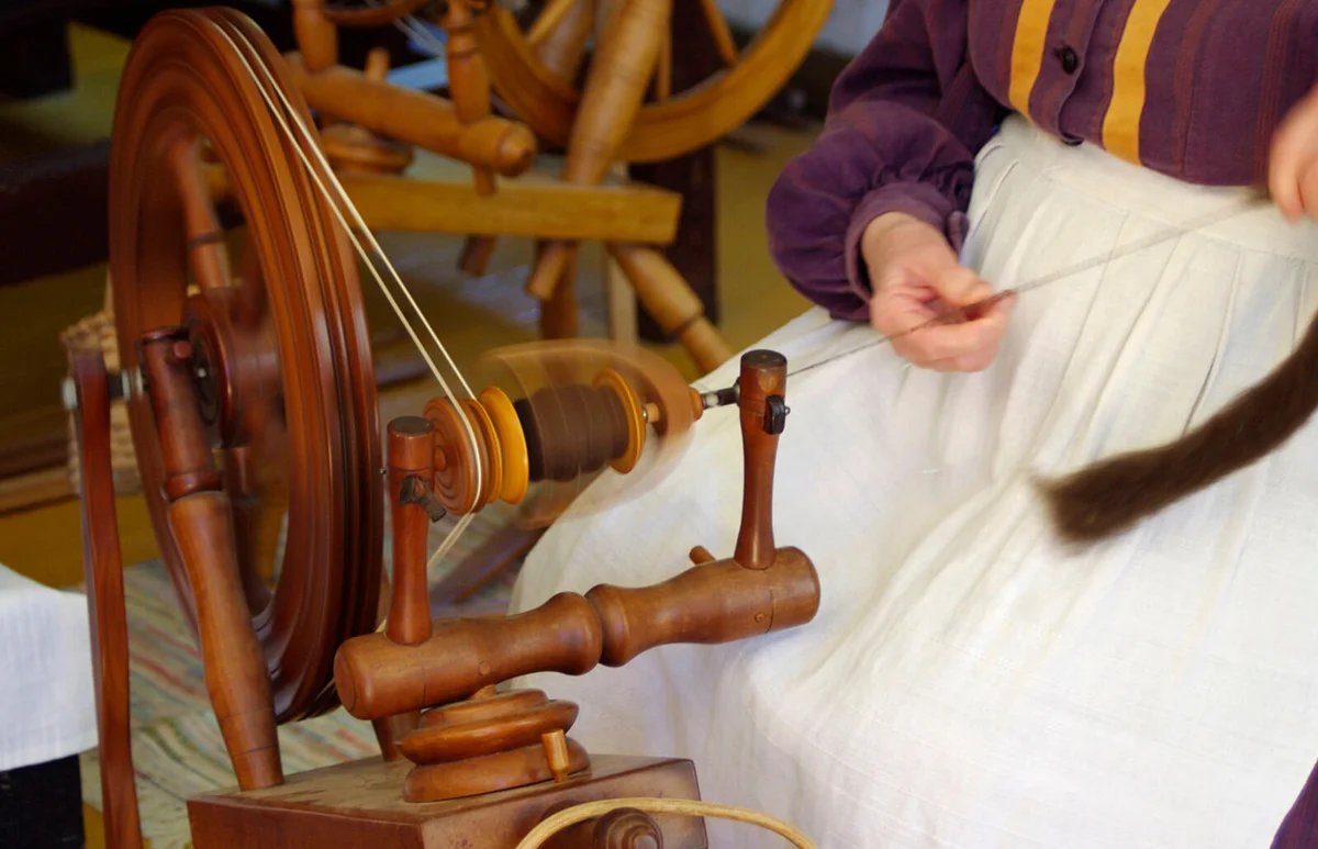 vintage wooden spinning wheel in use