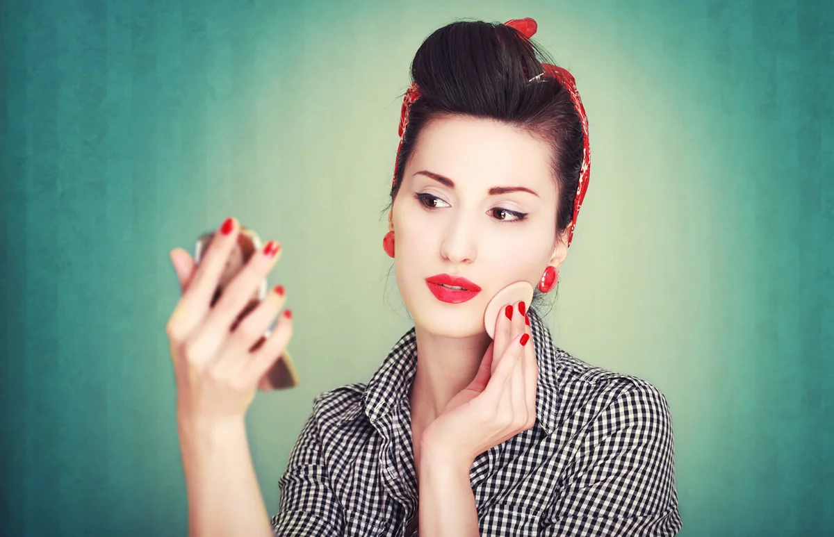 Vintage cross processed image of a young brunette in retro housewife clothes