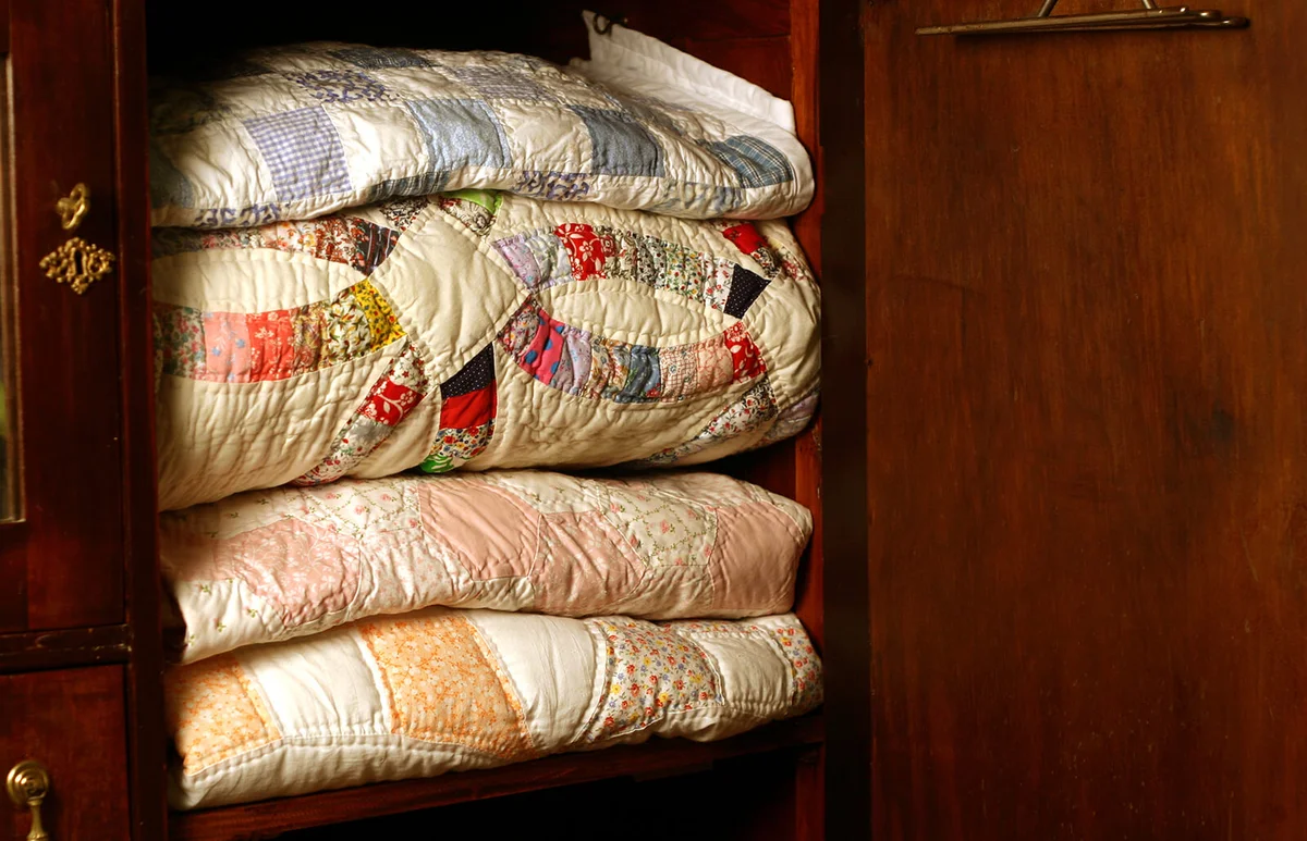 quilts in an antique mahogany wardrobe