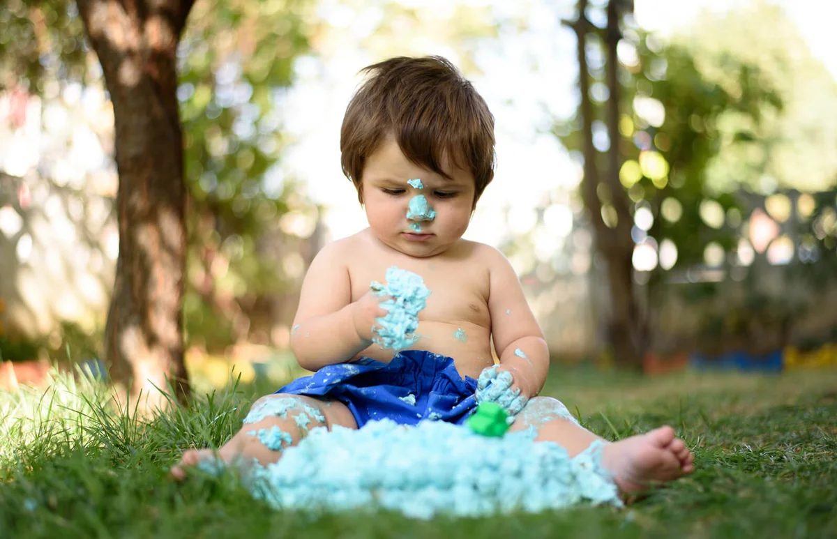 Baby playing with a cake during cake smash birthday party