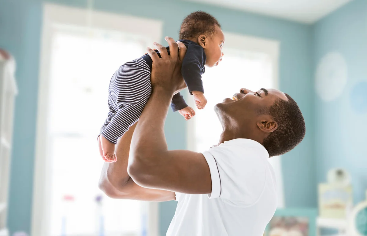 father lifting baby son