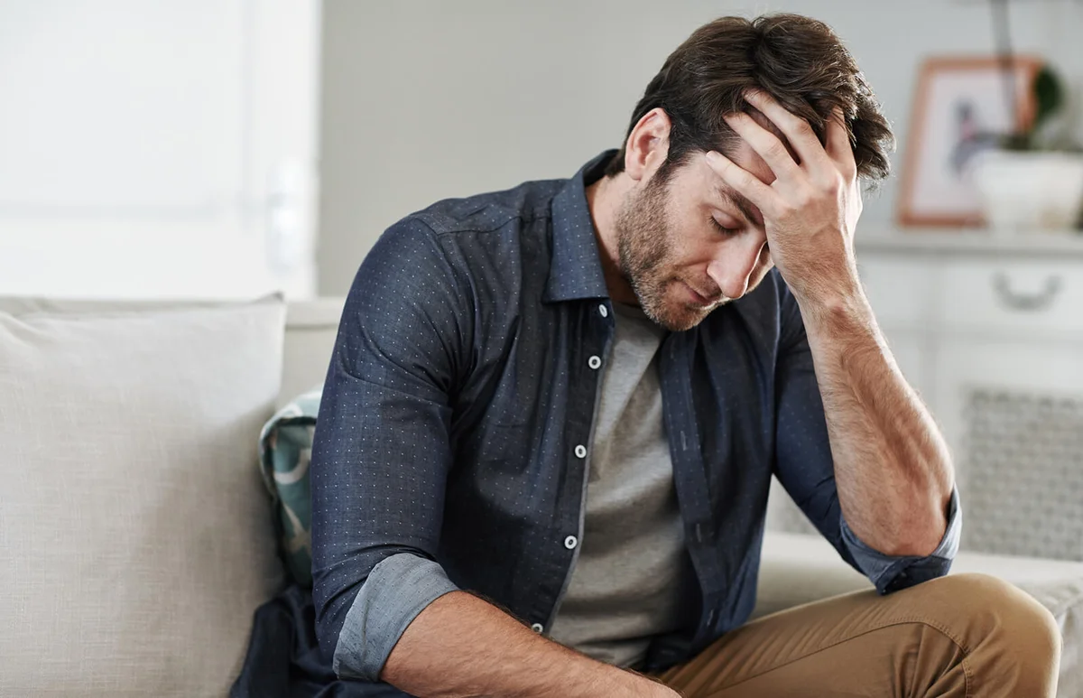 Man sitting alone at home looking sad and distraught