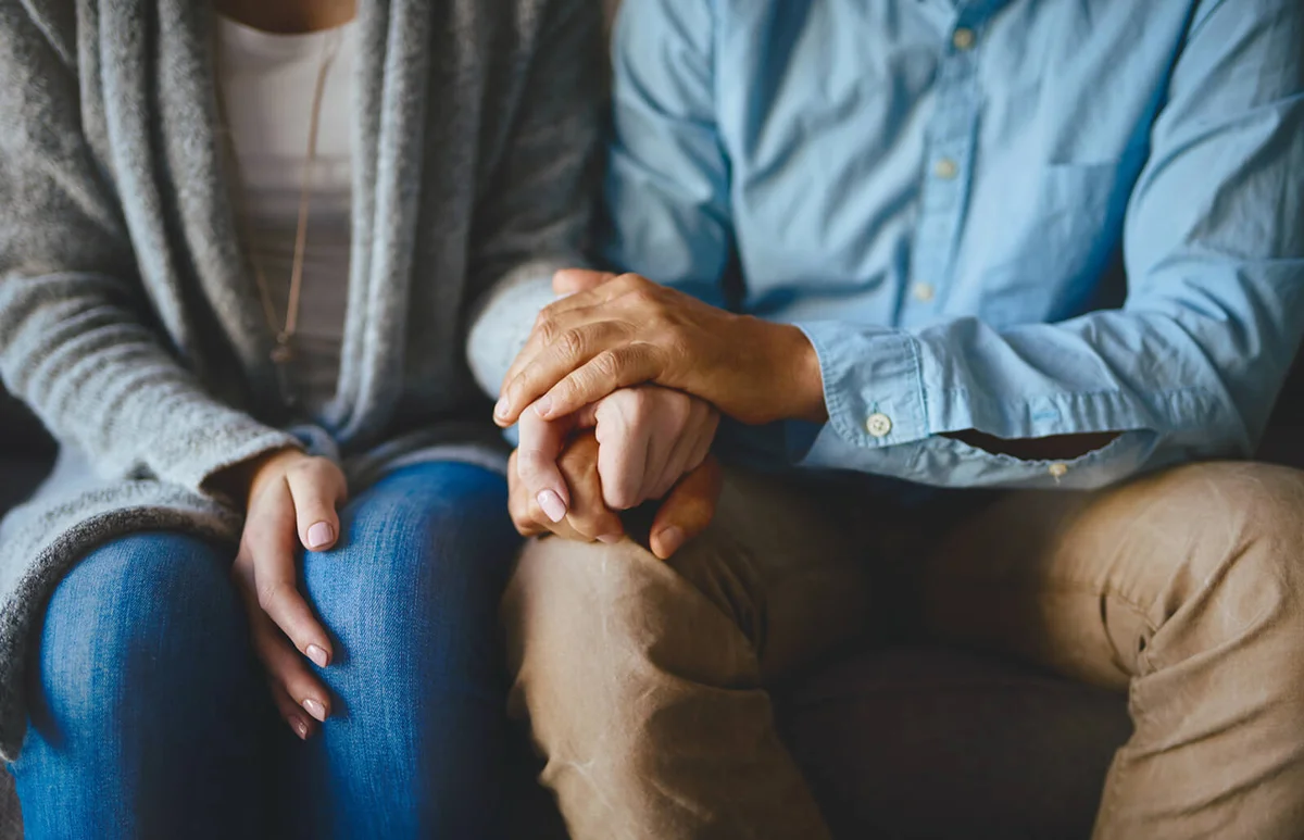 couple holding hands in comfort
