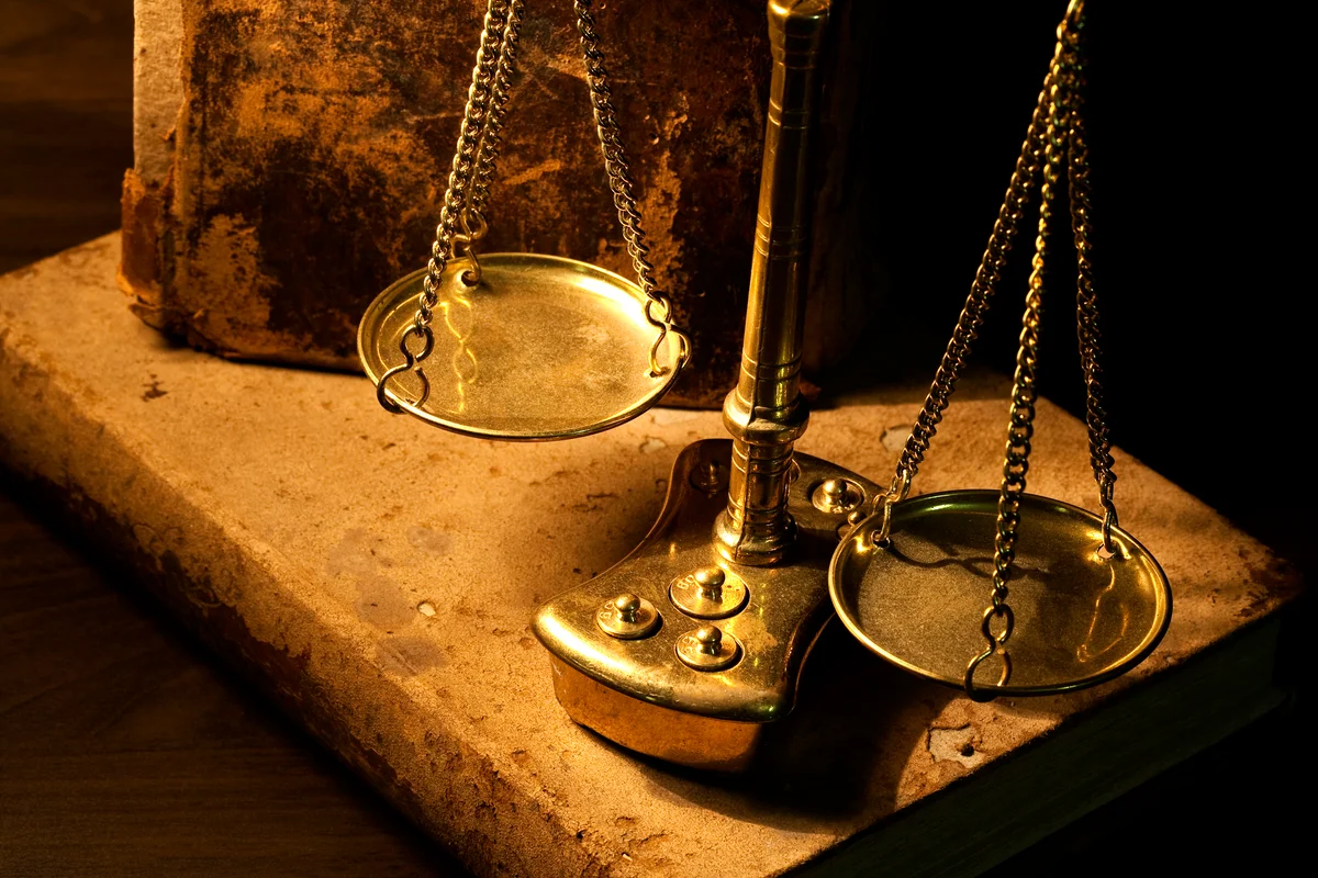 Ancient scale and old books on wooden table