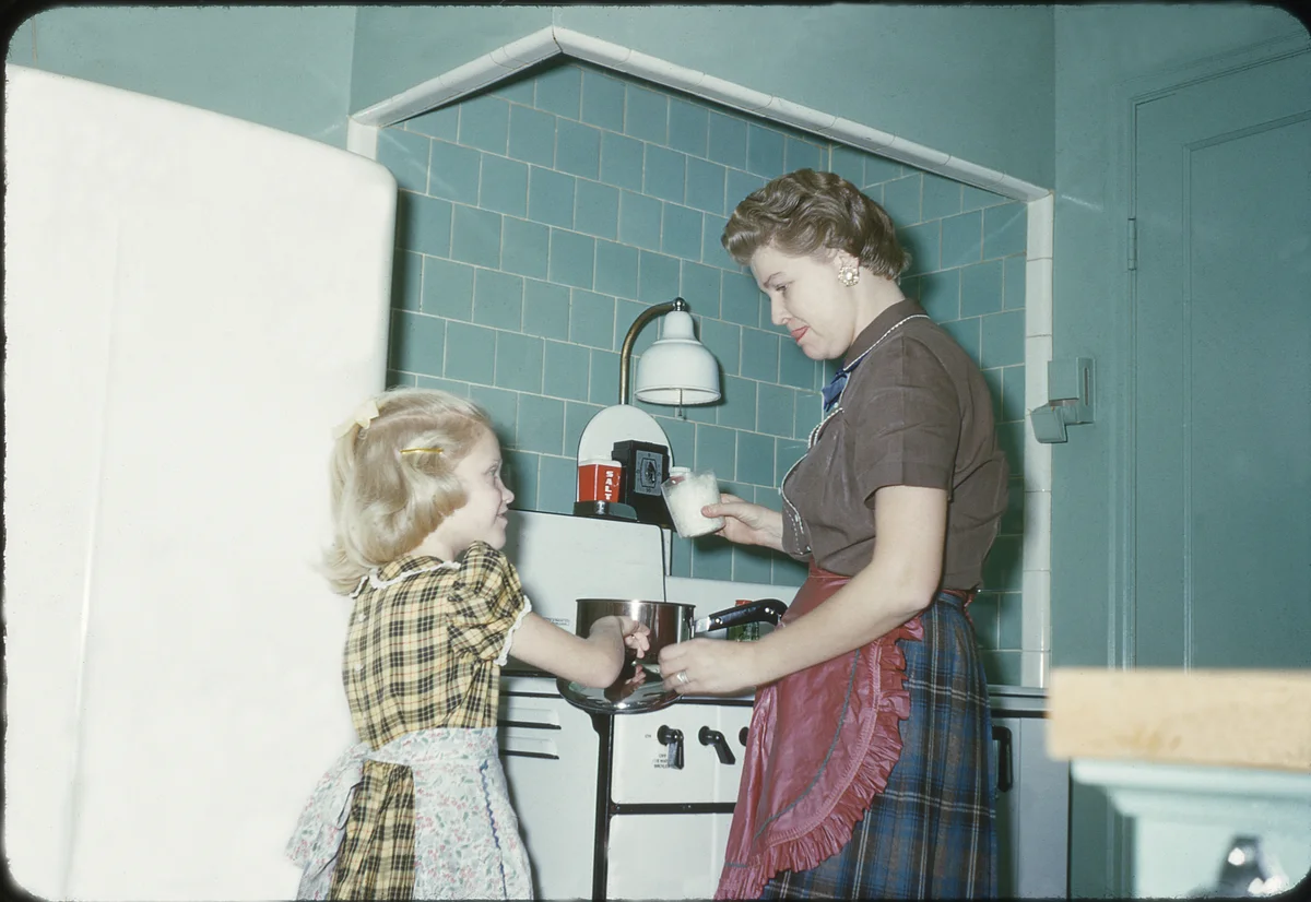 1950s mother teaching her daughter how to cook
