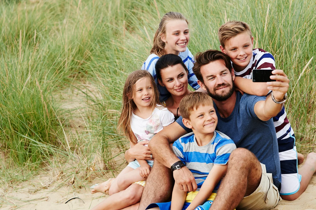 Family taking a selfie on beach sand dune