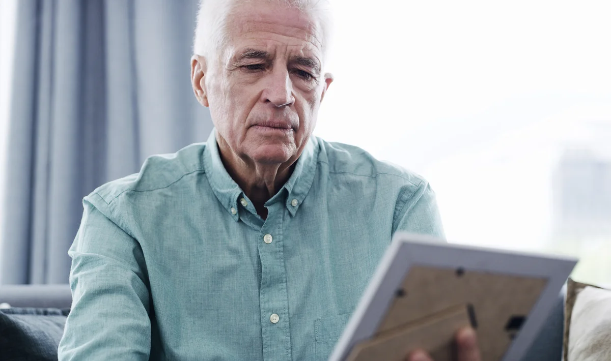 Sad man looking at a photo