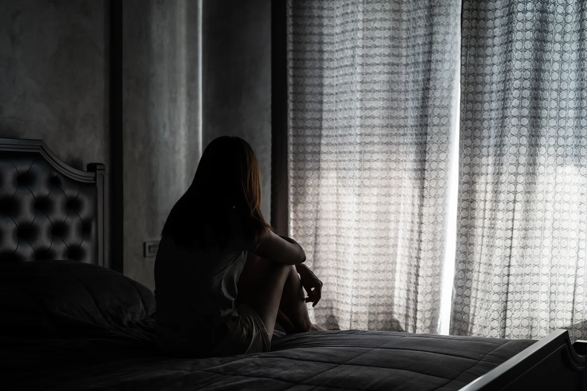 Woman sitting alone in dark room