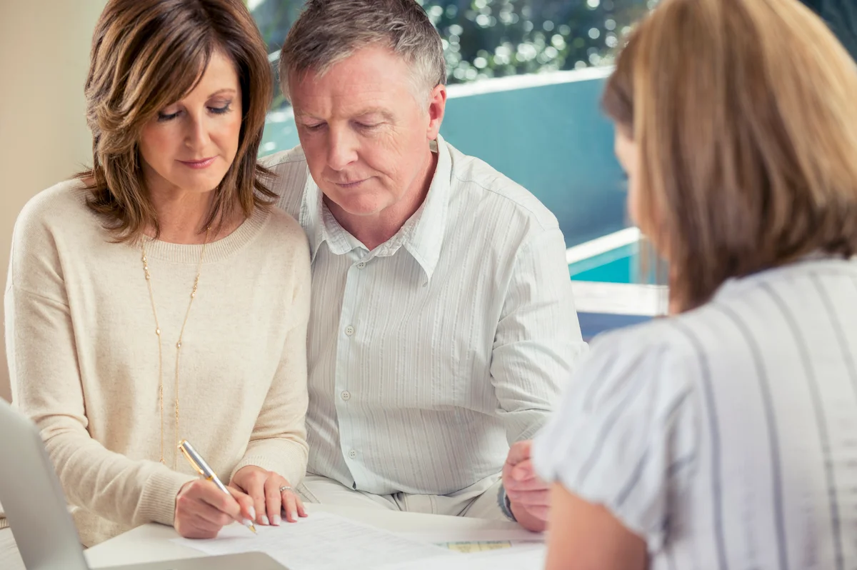 Man and woman signing wills with lawyer