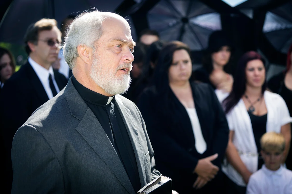 A clergyman delivering a eulogy at a funeral