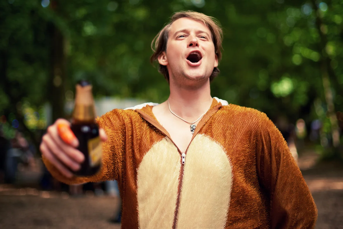 Man wearing animal costume holding beer bottle