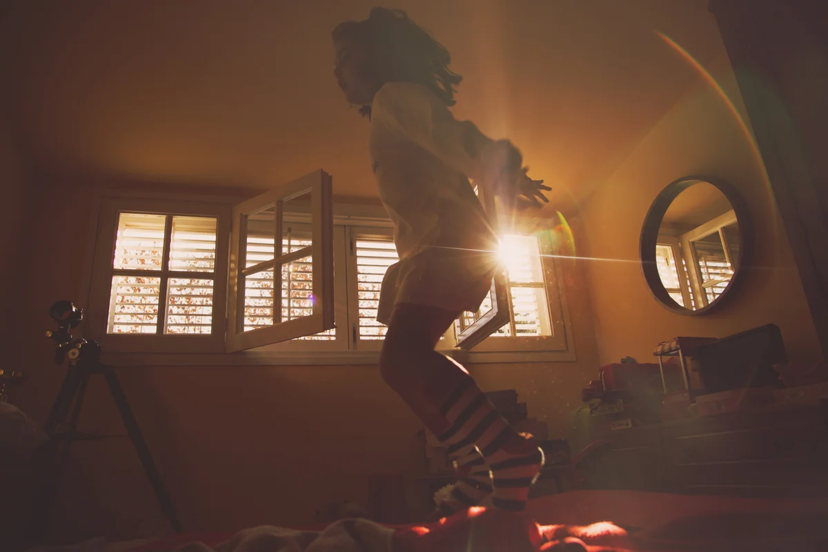 Girl jumping on bed