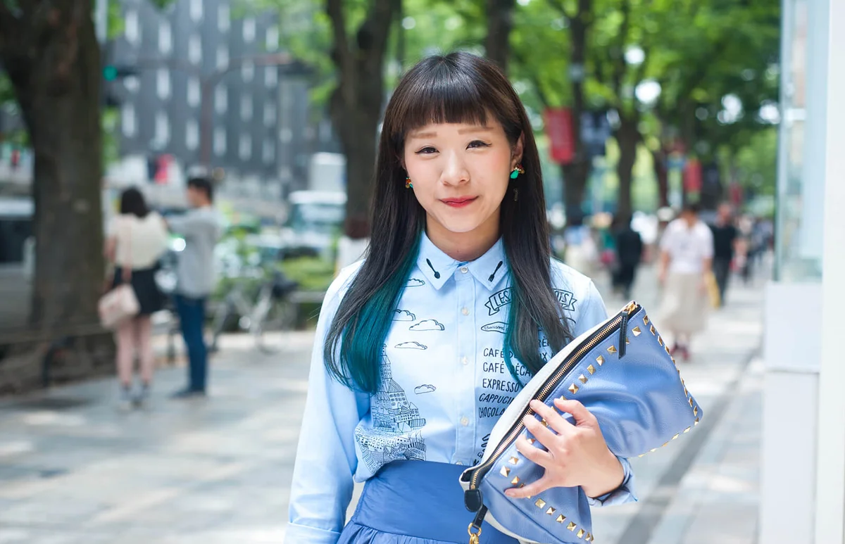 Japanese stylish woman standing on street and smiling