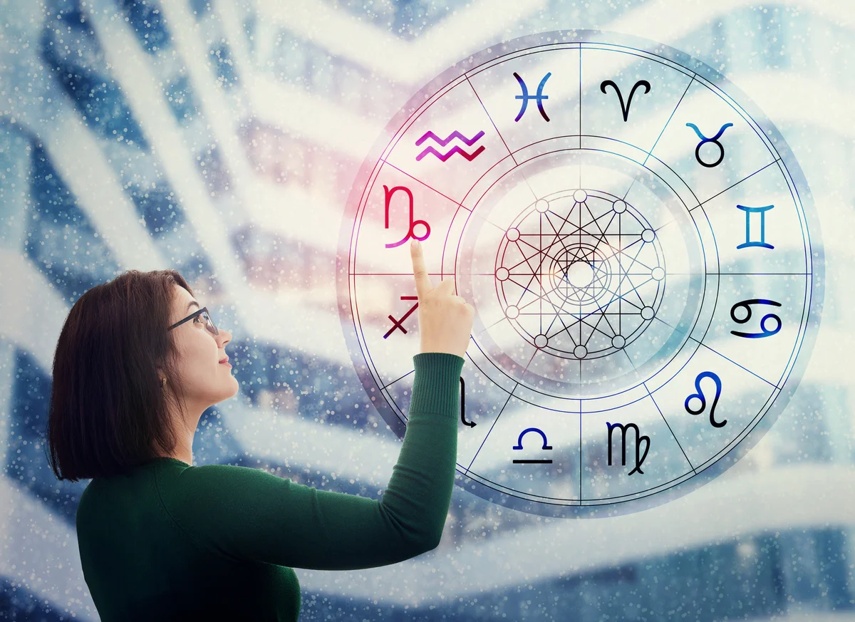 Woman choosing a zodiac sign from the astrological wheel