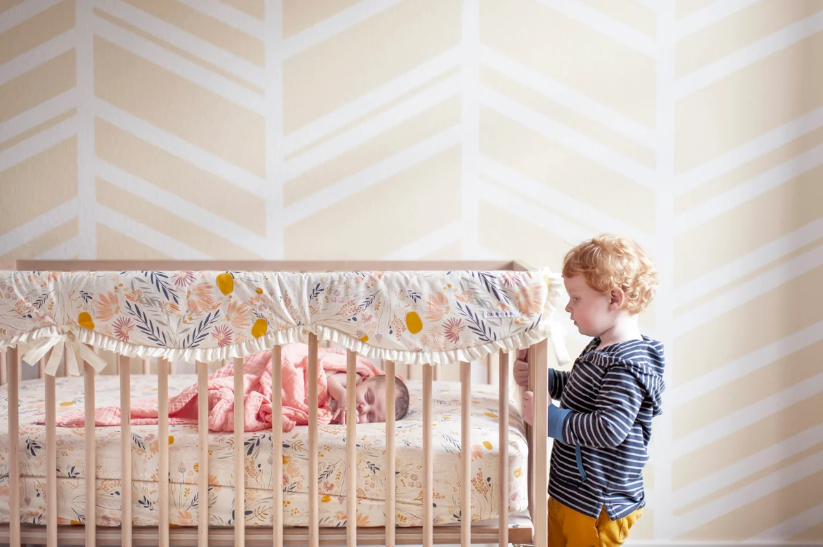 Nursery with pretty linens and patterned walls