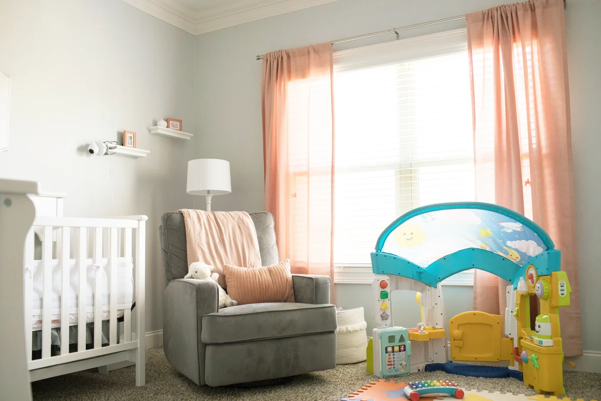 Infant nursery with crib with coral curtain